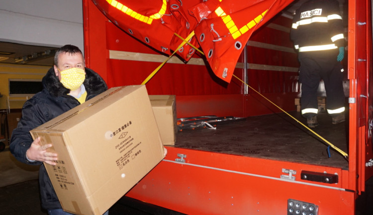 Starosta Ostrova Jan Bureš přebýrá zásilku ochranných pomůcek na kraji