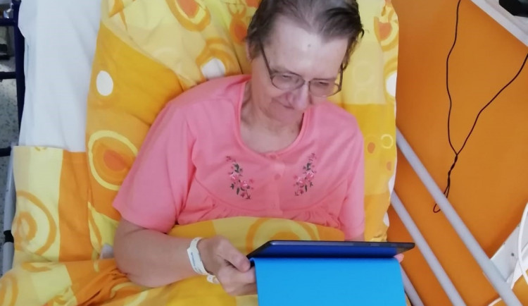 Seniorka komunikuje se svými blízkými pomocí tabletu