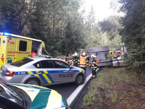 Dřevo z přívěsu se vysypalo na projíždějící auto, řidič skončil v nemocnici