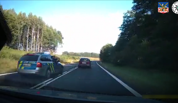 VIDEO: Vězně na útěku nezastavil ani výstřel. Policisty se pokusil vytlačit ze silnice