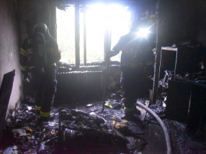 Hasiči z hořícího bytu zachránili uvězněné osoby, zbytek domu se musel evakuovat