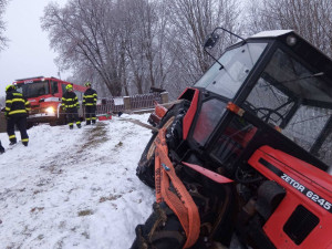 Hasiči vyprošťovali traktor na údržbu sněhu, hrozilo nebezpečí, že se zřítí z prudkého svahu