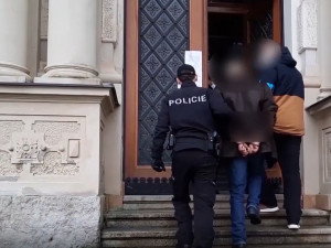 Policisté eskortují obviněného muže k soudu
