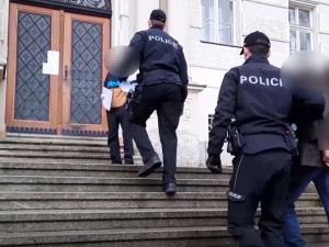 Policisté eskortují obviněného muže k soudu