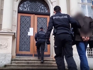 Policisté eskortují obviněného muže k soudu
