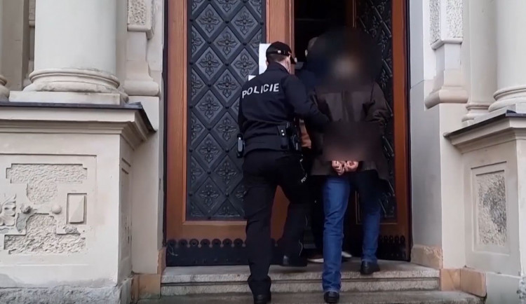 Policisté eskortují obviněného muže k soudu