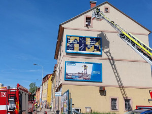 Bytový dům v Karlových Varech zachvátil požár. Hasiči zachraňovali obyvatele z žebříku