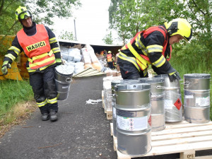 Kamion převážející nebezpečné látky skončil po střetu s osobákem převrácený mimo vozovku