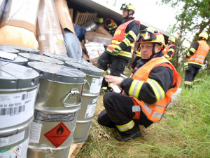 Kamion převážející nebezpečné látky skončil po střetu s osobákem převrácený mimo vozovku