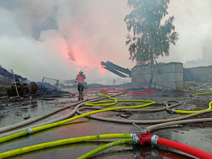 Požár skládky pražců se podařilo zredukovat na polovinu, kouř stále cítit ve velké části kraje