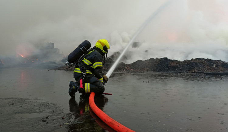 Skládka pražců u Tisové na Sokolovsku stále hoří, požár se ale daří zmenšovat