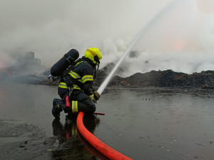 Skládka pražců u Tisové na Sokolovsku stále hoří, požár se ale daří zmenšovat