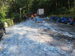 Z náklaďáku se v zatáčce vysypal náklad, silnici kompletně pokryly střepy z lahví na minerálku