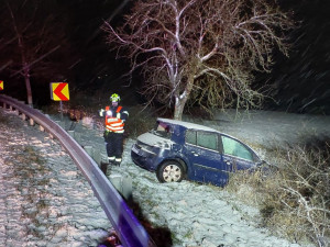Auto dostalo na kluzké vozovce smyk a přimáčklo k dalšímu vozu chodkyni. Žena utrpěla těžké zranění