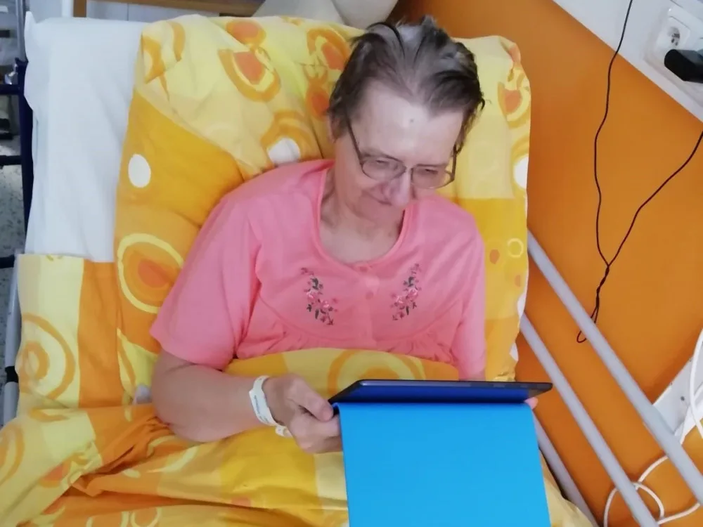 Seniorka komunikuje se svými blízkými pomocí tabletu