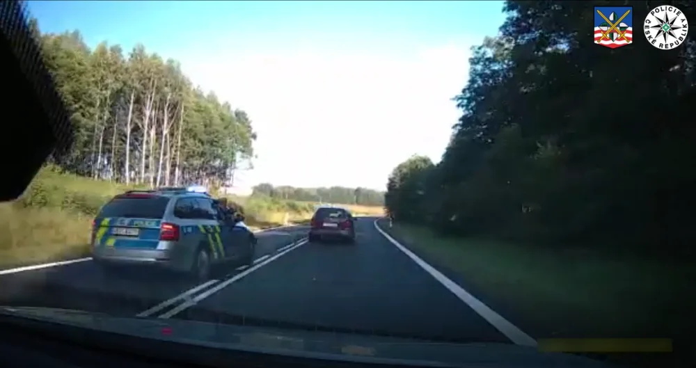 VIDEO: Vězně na útěku nezastavil ani výstřel. Policisty se pokusil vytlačit ze silnice