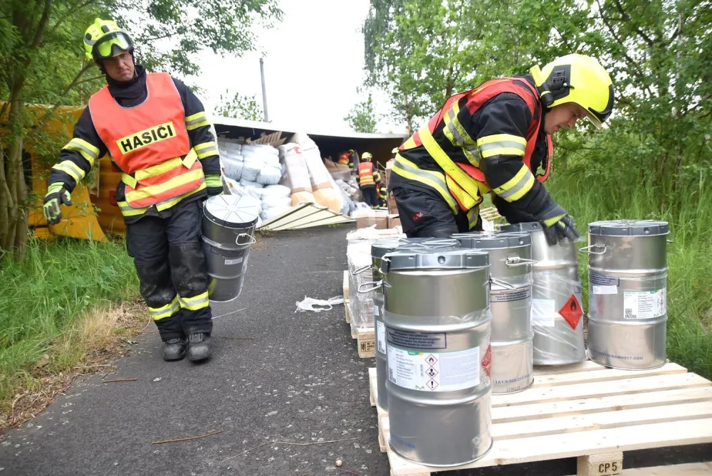 Kamion převážející nebezpečné látky skončil po střetu s osobákem převrácený mimo vozovku