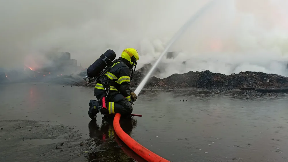 Požár skládky pražců se podařilo zredukovat na polovinu, kouř stále cítit ve velké části kraje