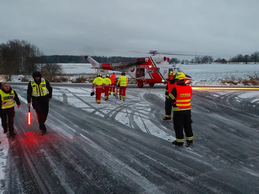 Auto dostalo na kluzké vozovce smyk a přimáčklo k dalšímu vozu chodkyni. Žena utrpěla těžké zranění