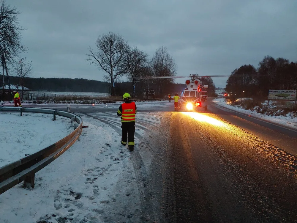 Auto dostalo na kluzké vozovce smyk a přimáčklo k dalšímu vozu chodkyni. Žena utrpěla těžké zranění