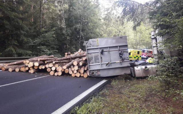 Dřevo z přívěsu se vysypalo na projíždějící auto, řidič skončil v nemocnici
