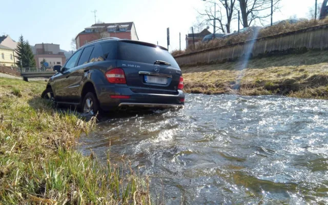 Mercedes prorazil plot a zřítil se z vysokého srázu až do koryta řeky