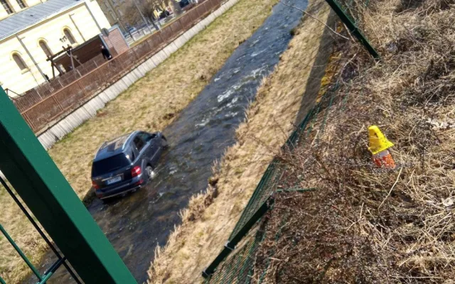 Mercedes prorazil plot a zřítil se z vysokého srázu až do koryta řeky