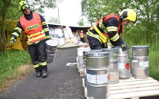 Kamion převážející nebezpečné látky skončil po střetu s osobákem převrácený mimo vozovku