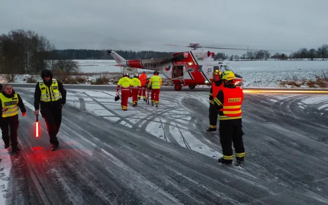 Auto dostalo na kluzké vozovce smyk a přimáčklo k dalšímu vozu chodkyni. Žena utrpěla těžké zranění
