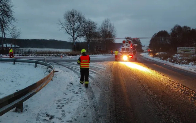 Auto dostalo na kluzké vozovce smyk a přimáčklo k dalšímu vozu chodkyni. Žena utrpěla těžké zranění
