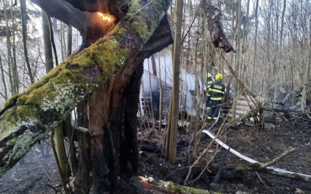 Hasiči ráno likvidovali požár chaty, hořely i stromy a suchá tráva na velké ploše přilehlé louky