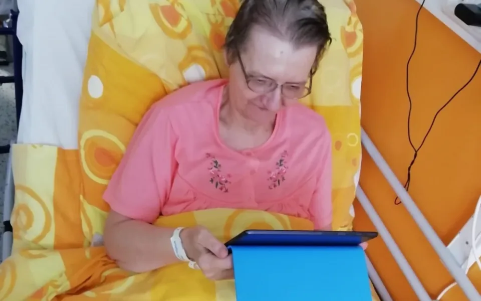 Seniorka komunikuje se svými blízkými pomocí tabletu