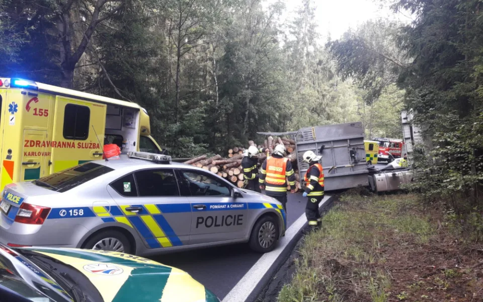 Dřevo z přívěsu se vysypalo na projíždějící auto, řidič skončil v nemocnici