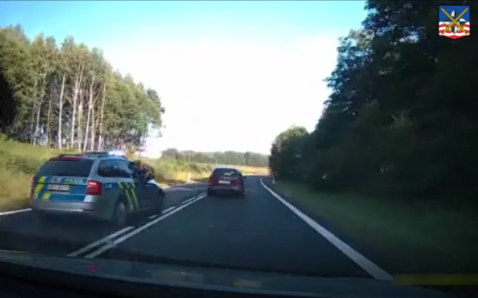 VIDEO: Vězně na útěku nezastavil ani výstřel. Policisty se pokusil vytlačit ze silnice