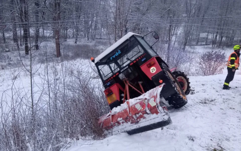 Hasiči vyprošťovali traktor na údržbu sněhu, hrozilo nebezpečí, že se zřítí z prudkého svahu