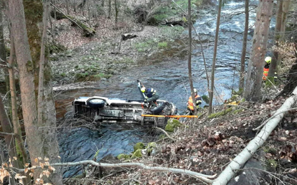 Auto sjelo z osmimetrového srázu a skončilo v řece. Vyprostit ho museli hasiči