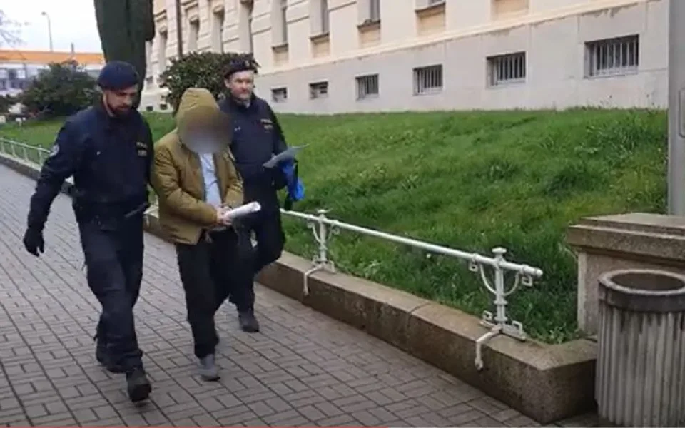 Policisté eskortují k soudu staršího z dvojice útočníků, který pak putoval do vazby